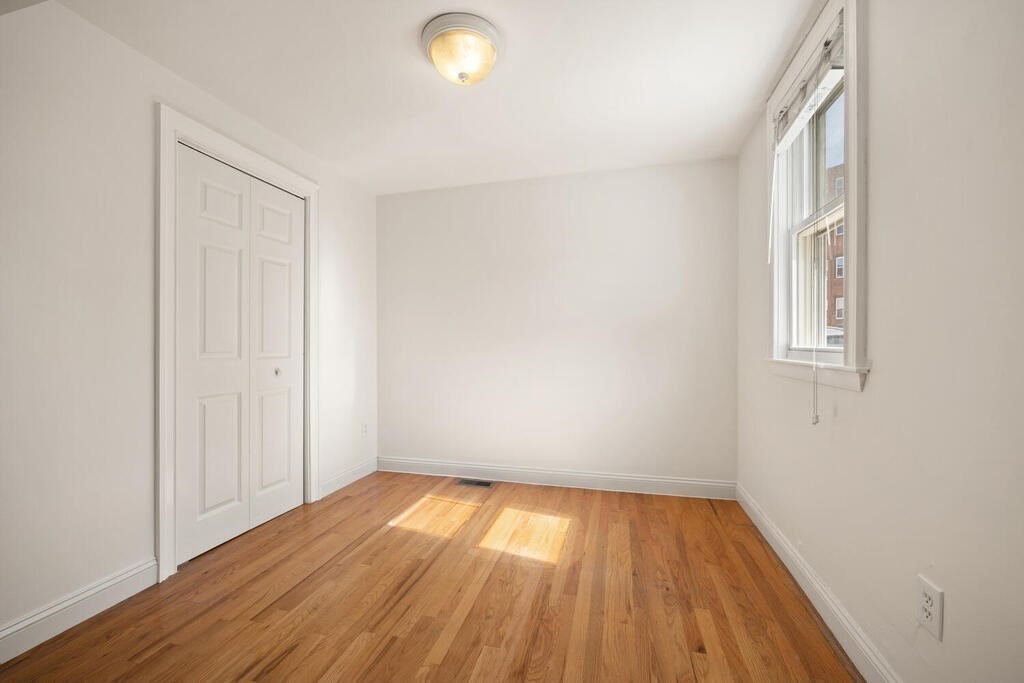 280 E Street, Unit 1 Boston, MA 02127 - Photo 14 of 19 an empty room with wooden floor and windows
