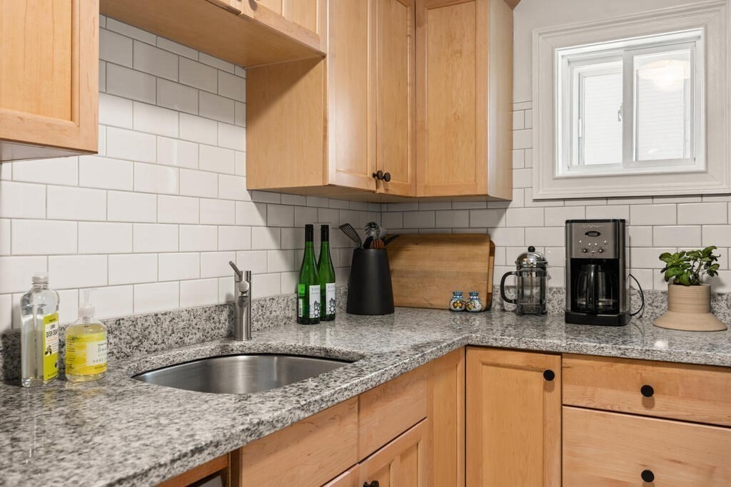 280 E Street, Unit 1 Boston, MA 02127 - Photo 7 of 19 a kitchen with granite countertop a sink and a white wooden cabinets
