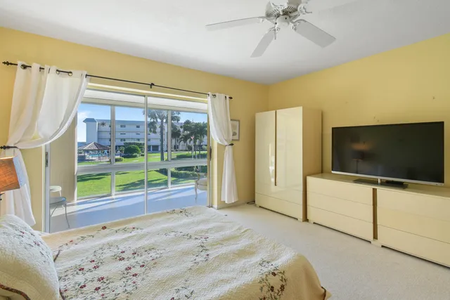 a bedroom with a bed and a flat tv screen on dresser