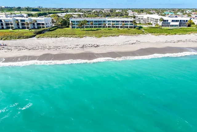 an aerial view of a houses with a ocean view