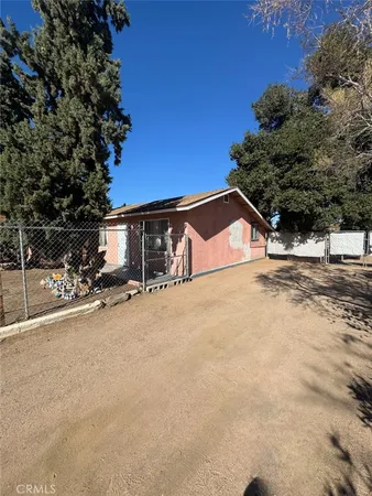 a view of parking and house with trees in front of it