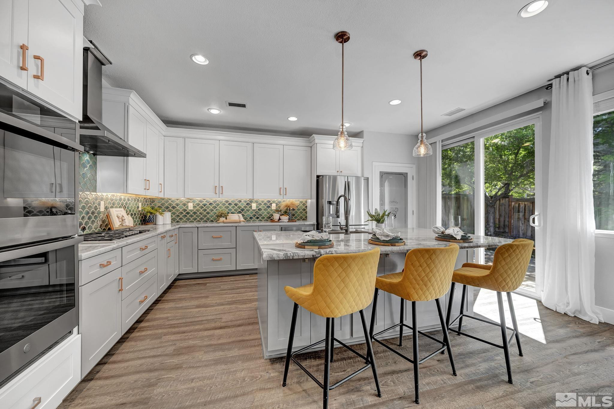 11355 Crotone Way Reno, NV 89521 - Photo 12 of 39 a kitchen with stainless steel appliances granite countertop wooden floor cabinets and window