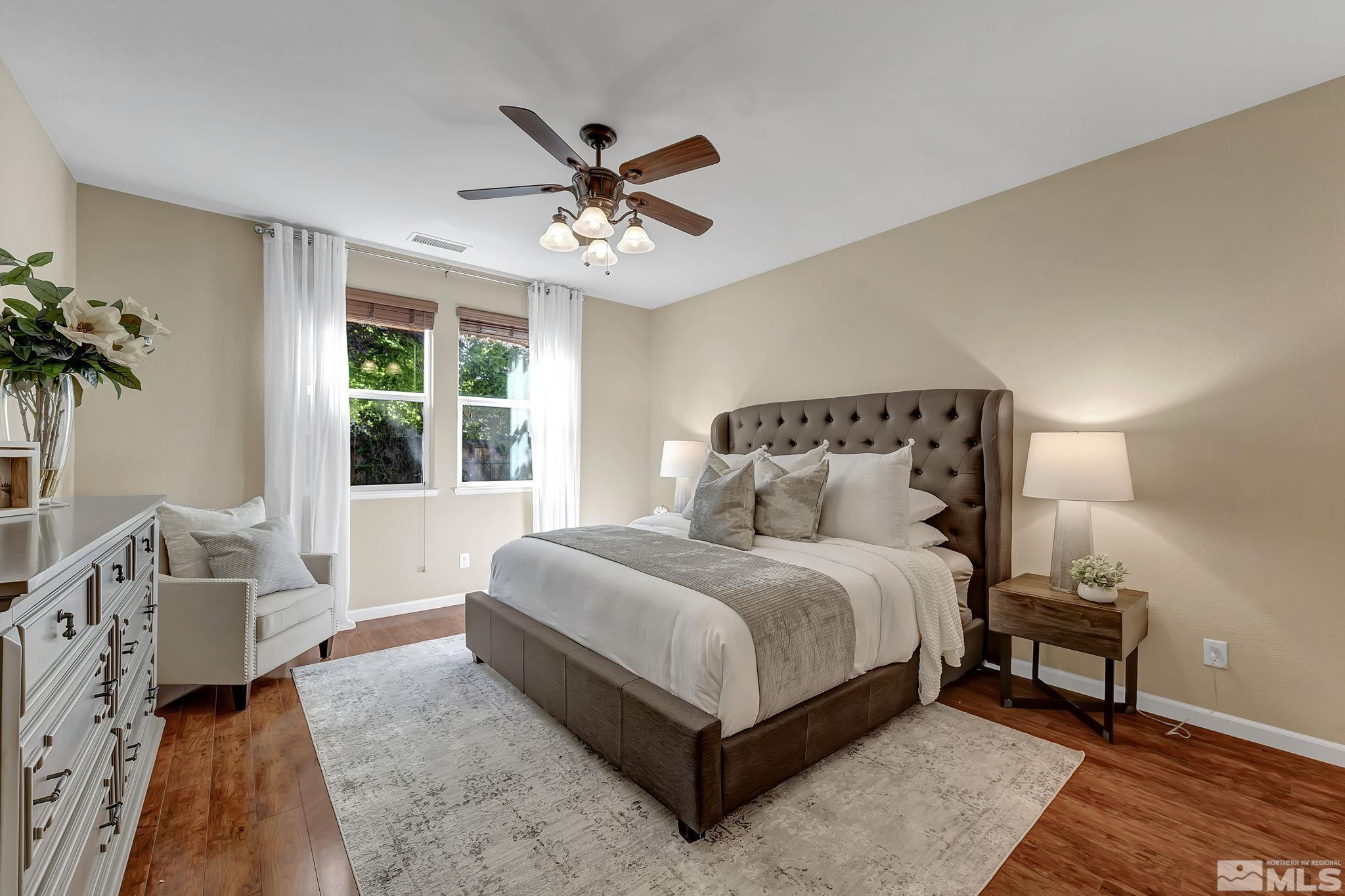 11355 Crotone Way Reno, NV 89521 - Photo 21 of 39 a spacious bedroom with a bed a couch and a potted plant