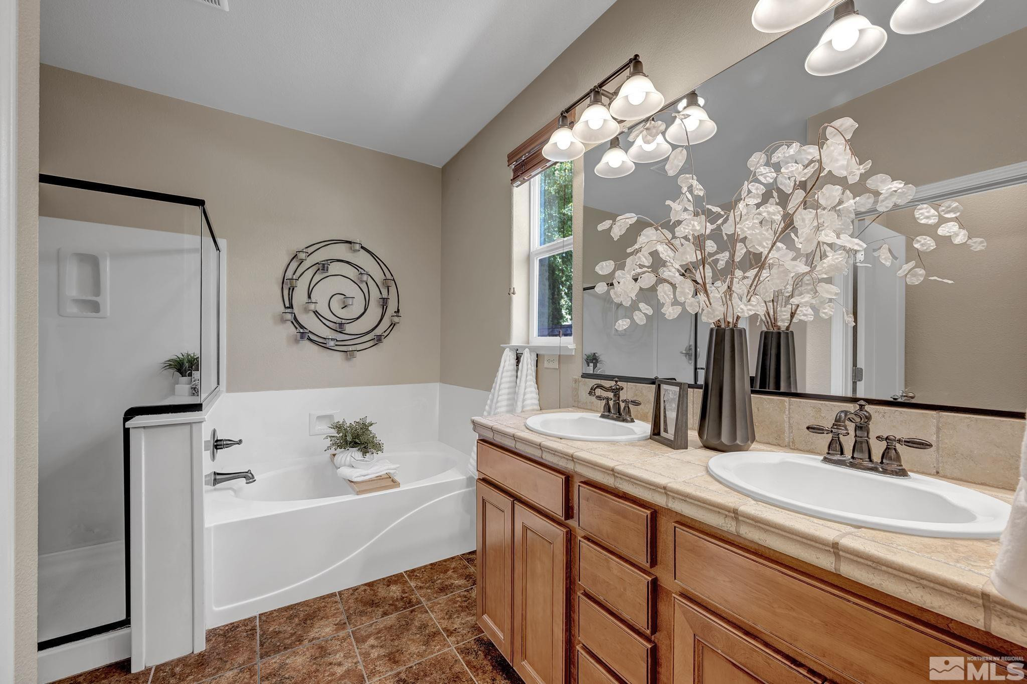 11355 Crotone Way Reno, NV 89521 - Photo 25 of 39 a bathroom with a bathtub a sink and a large mirror