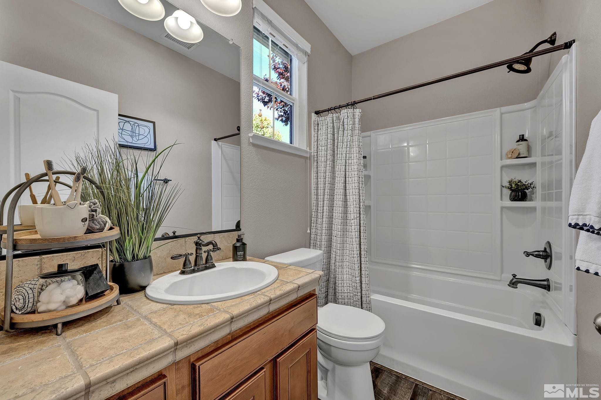 11355 Crotone Way Reno, NV 89521 - Photo 32 of 39 a bathroom with a granite countertop sink toilet and shower