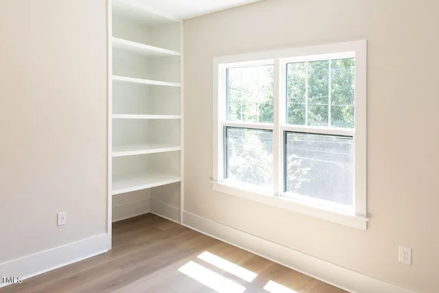 an empty room with windows and closet