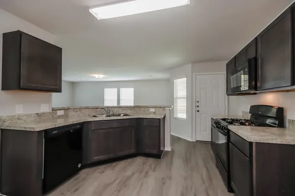 a kitchen with stainless steel appliances granite countertop a sink stove and microwave