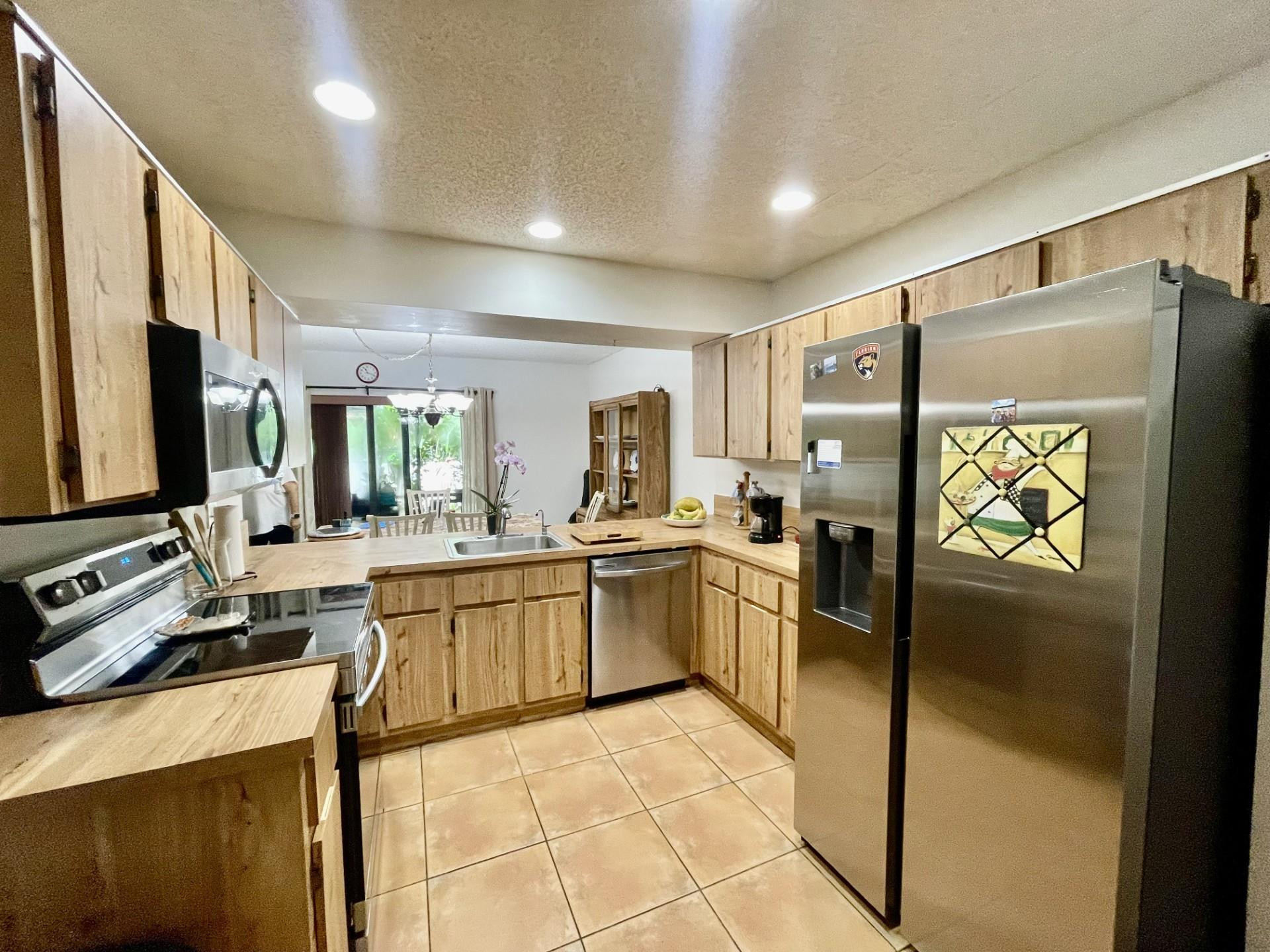 9787 Riverside Drive, Unit 624 Coral Springs, FL 33071 - Photo 4 of 21 a kitchen with stainless steel appliances granite countertop a refrigerator and a stove top oven
