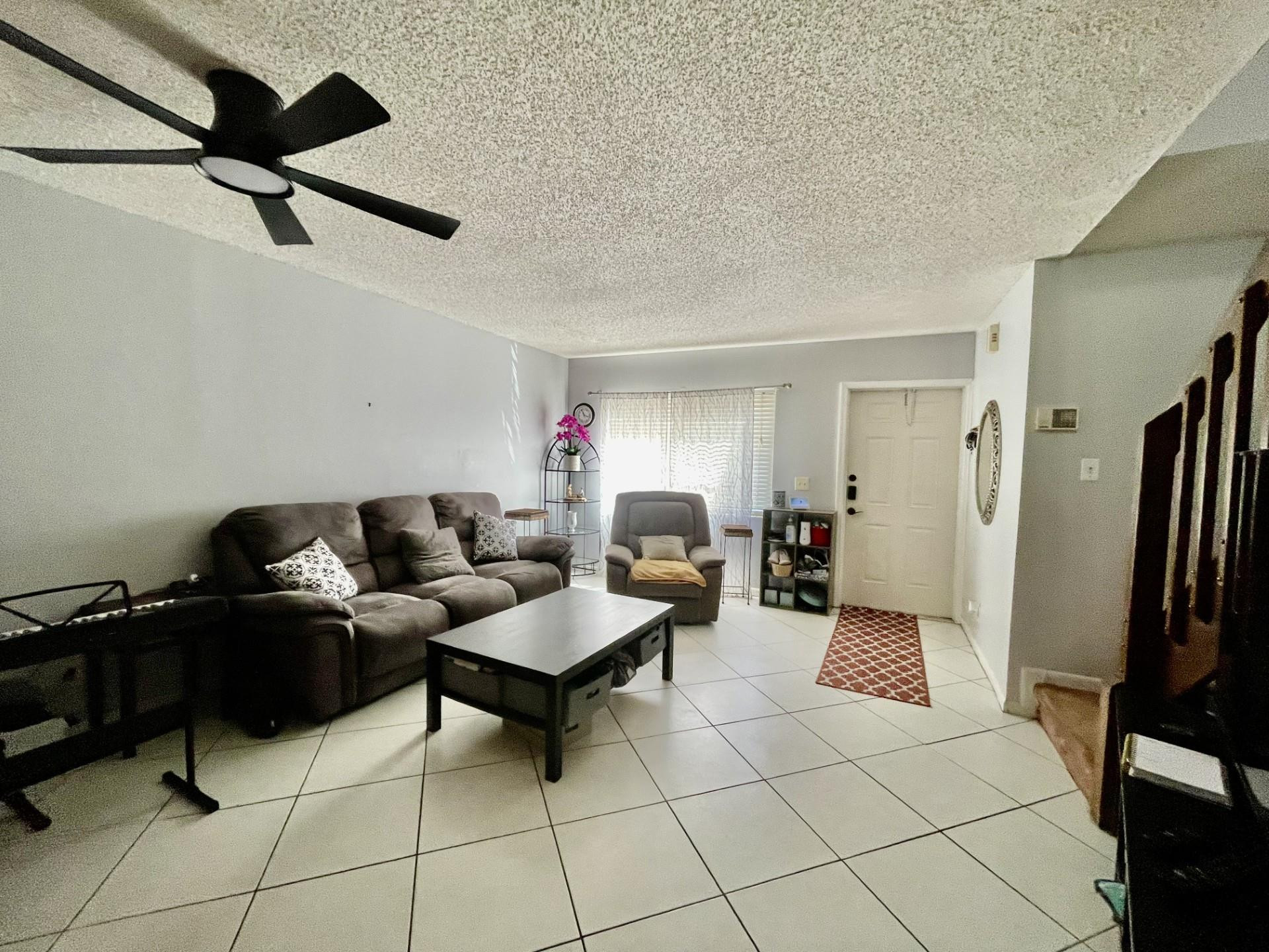 9787 Riverside Drive, Unit 624 Coral Springs, FL 33071 - Photo 9 of 21 a living room with furniture and a flat screen tv