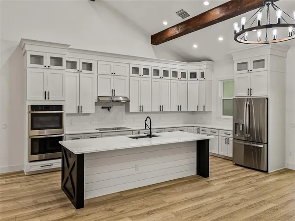 a kitchen with a stove and a wooden floor