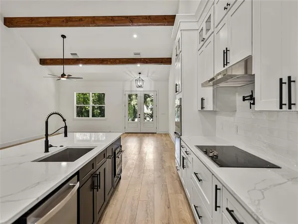 a kitchen with white cabinets and stainless steel appliances