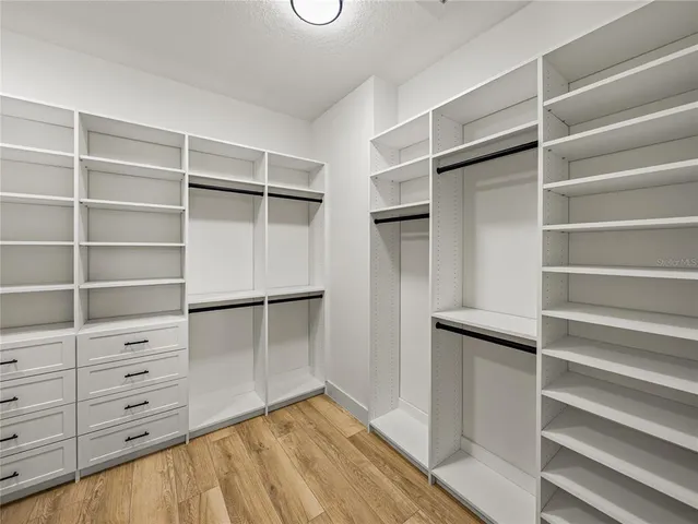 a view of walk in closet with empty racks