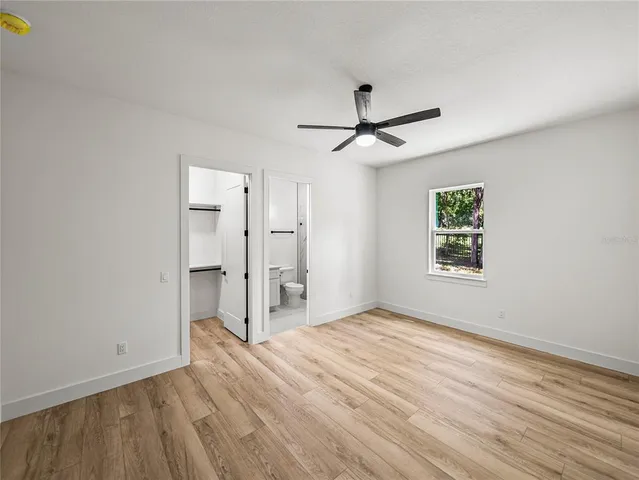 a view of a livingroom with a ceiling fan a ceiling fan and hardwood floor