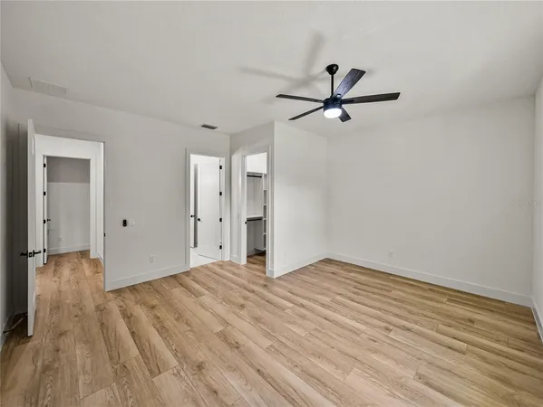 a view of empty room with wooden floor