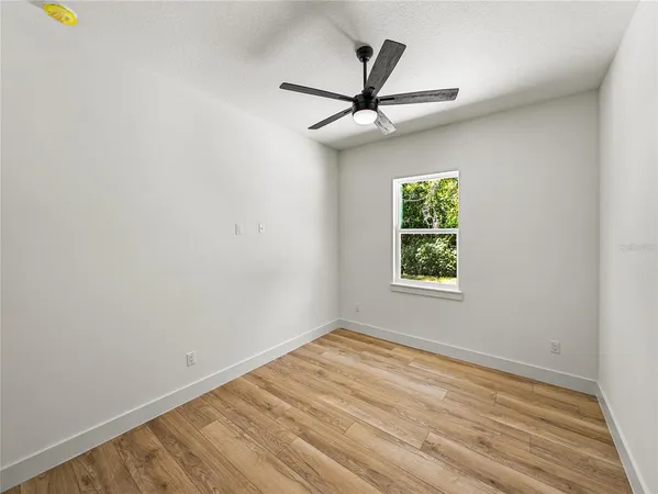 a view of a livingroom with a ceiling fan and window