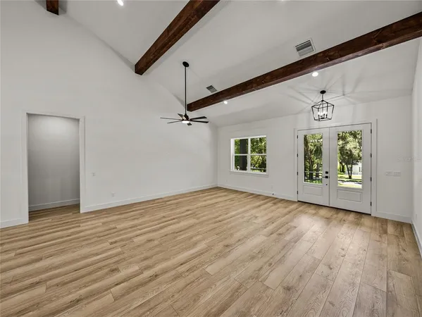 a view of a hallway with wooden floor and a ceiling fan