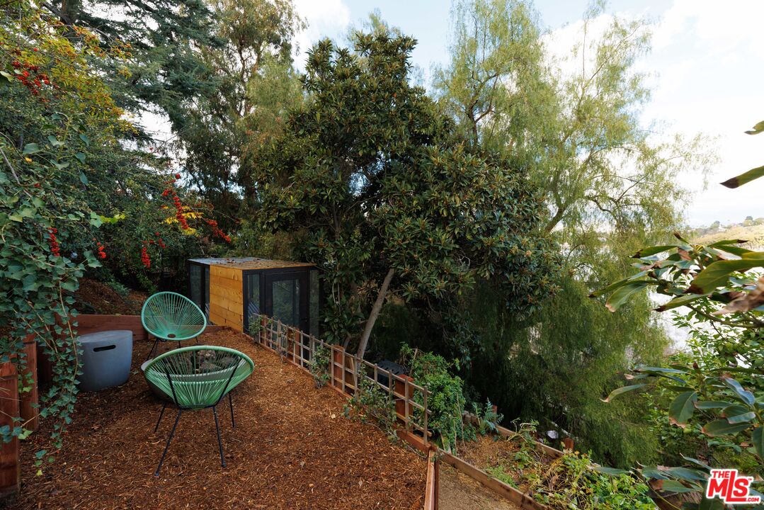 a backyard of a house with fountain plants and large trees