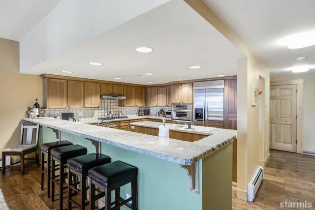 a kitchen with a table chairs sink and refrigerator