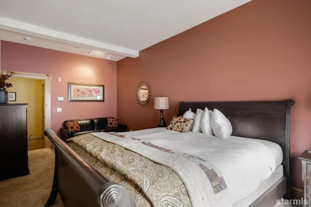 a bedroom with a large bed and a lamp