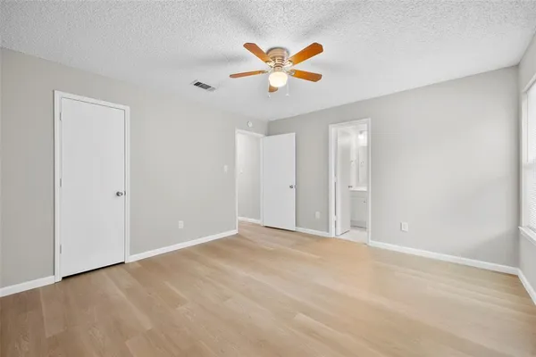 a view of an empty room with a ceiling fan