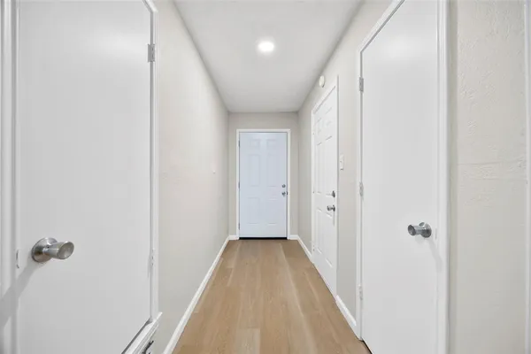 a view of a hallway with wooden floor