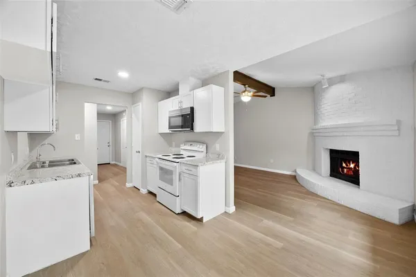 a kitchen with stainless steel appliances a stove top oven a sink and a refrigerator