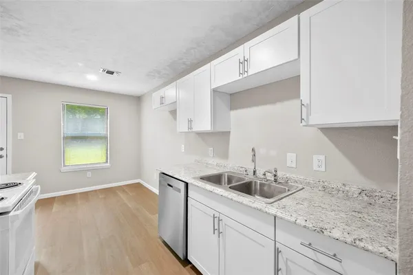 a kitchen with a sink a cabinets and window