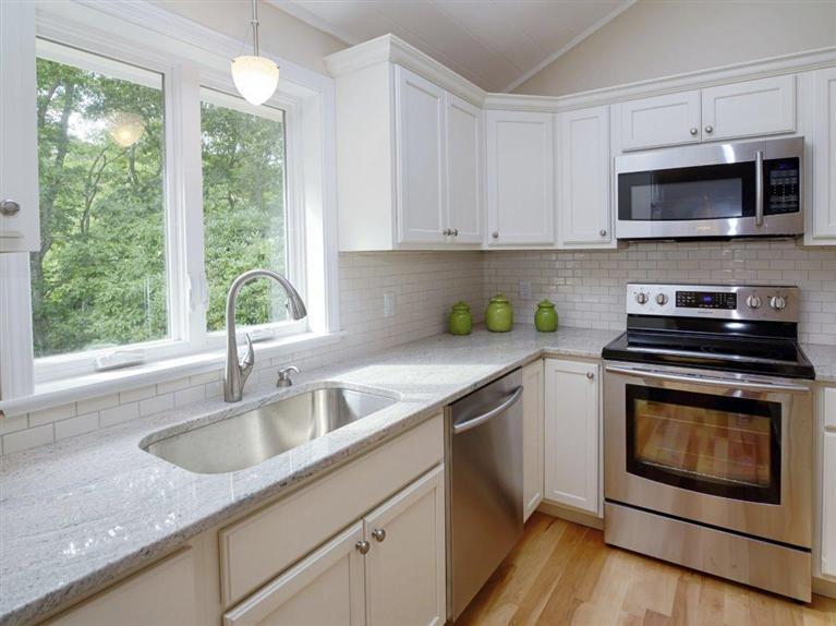 537 Scraggy Neck Road Cataumet, MA 02534 - Photo 16 of 33 a kitchen with stainless steel appliances granite countertop a sink a stove a microwave and wooden cabinets