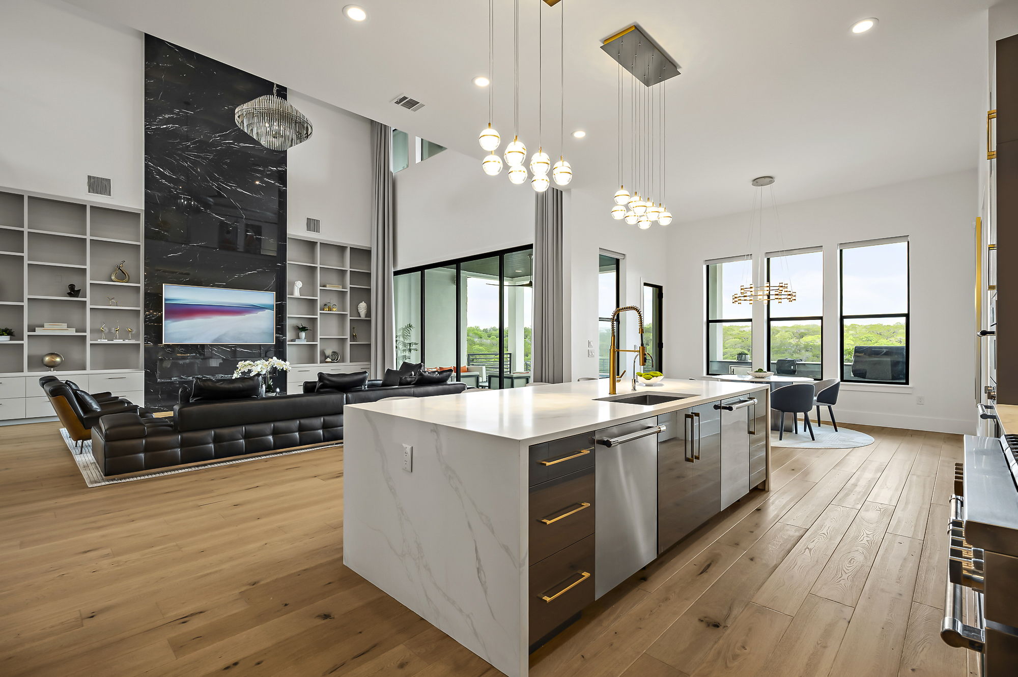 10211 Thistle Ridge Austin, TX 78733 - Photo 14 of 39 Kitchen with a chandelier, modern cabinets, stainless steel dishwasher, a center island with sink, and light wood-style floors