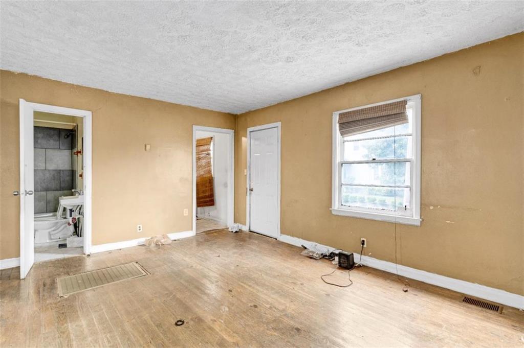 943 Washington Place Southwest Atlanta, GA 30314 - Photo 15 of 25 a view of an empty room with wooden floor and a window