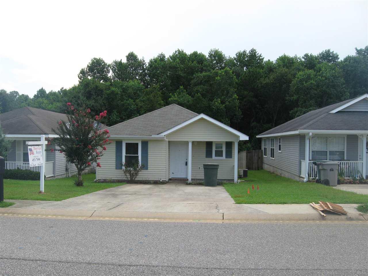 1147 Brownfield Road Pensacola, FL 32526 - Photo 1 of 1 a front view of a house with a garden and trees