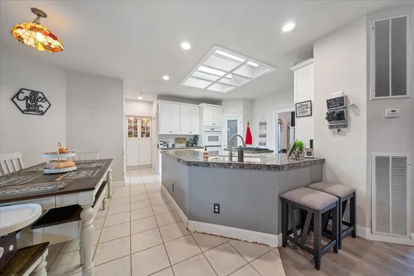 a kitchen with stainless steel appliances granite countertop a sink window and cabinets