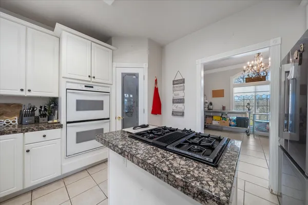 a large kitchen with stainless steel appliances granite countertop a refrigerator and a sink