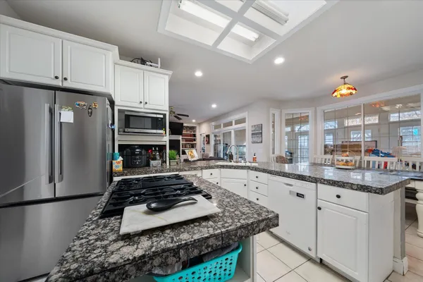 a kitchen with stainless steel appliances granite countertop a refrigerator and a stove