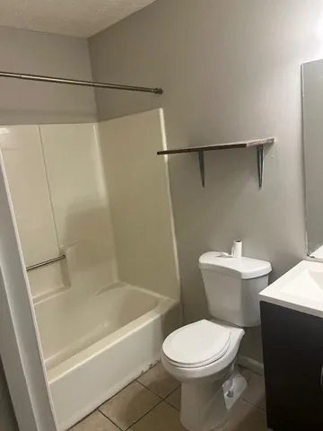 a white toilet sitting next to a bath tub