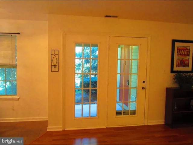 a view of a room with gym equipment and wooden floor