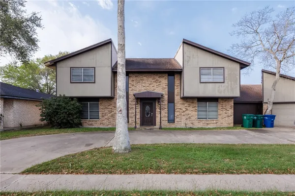 a view of a yard with brick wall and a large window