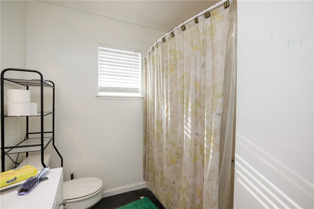 4029 Congressional Drive Corpus Christi, TX 78413 - Photo 22 of 34 a white toilet sitting next to a shower curtain