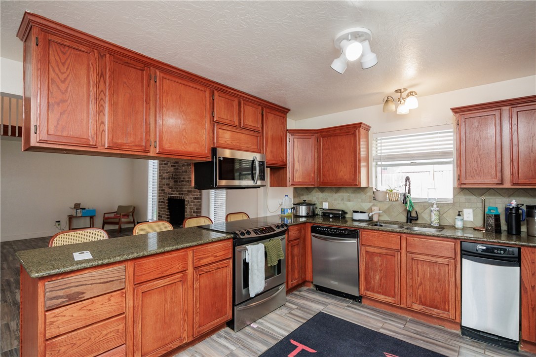 4029 Congressional Drive Corpus Christi, TX 78413 - Photo 6 of 34 a kitchen with stainless steel appliances granite countertop a sink a stove cabinets counter space and a window