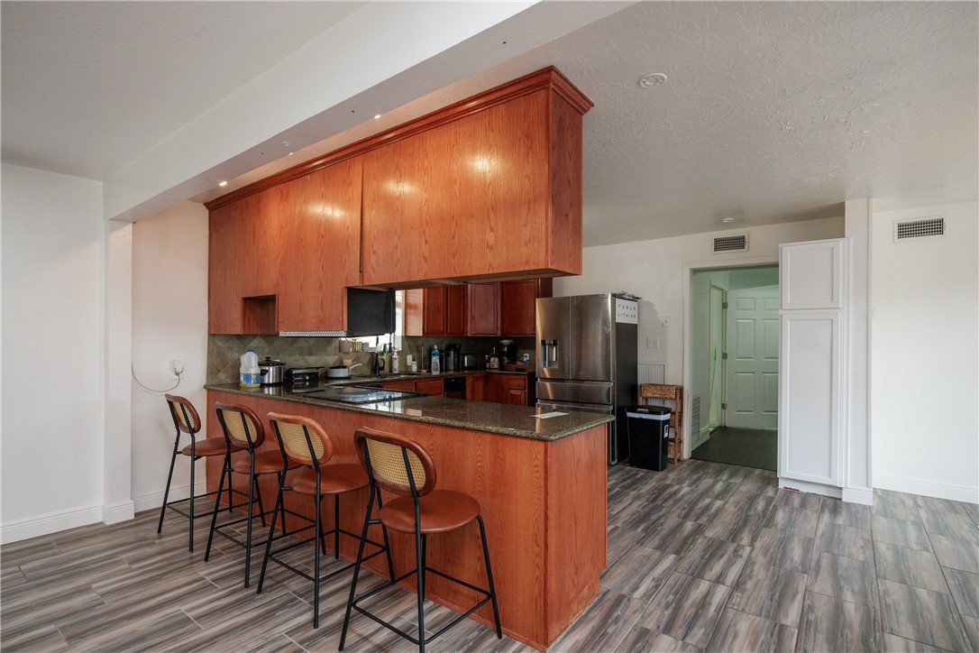 4029 Congressional Drive Corpus Christi, TX 78413 - Photo 8 of 34 a kitchen with stainless steel appliances a dining table chairs stove refrigerator and cabinets
