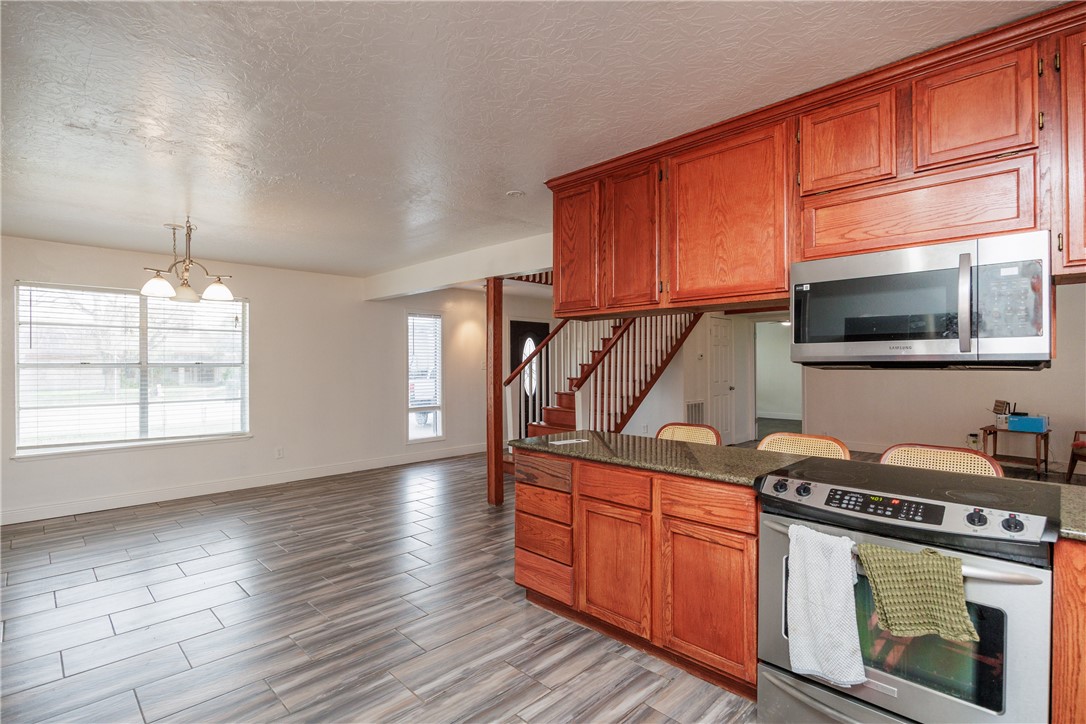 4029 Congressional Drive Corpus Christi, TX 78413 - Photo 9 of 34 a kitchen with stainless steel appliances granite countertop a stove a sink and a microwave