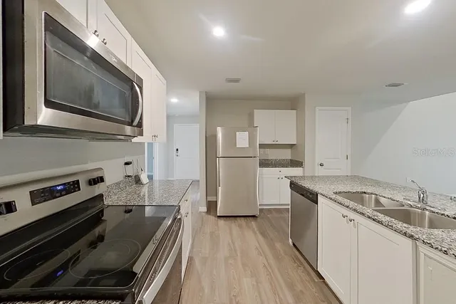 a kitchen with granite countertop stainless steel appliances and wooden cabinets