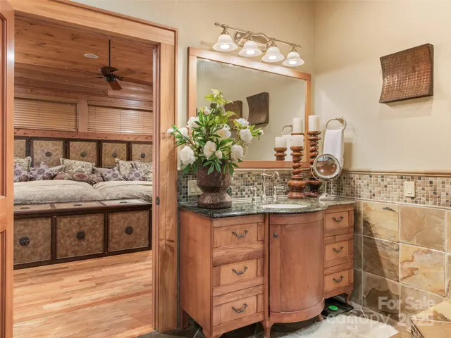 a bathroom with a granite countertop sink a mirror and shower