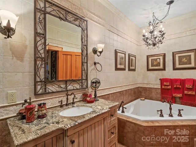 a bathroom with a granite countertop tub sink and mirror
