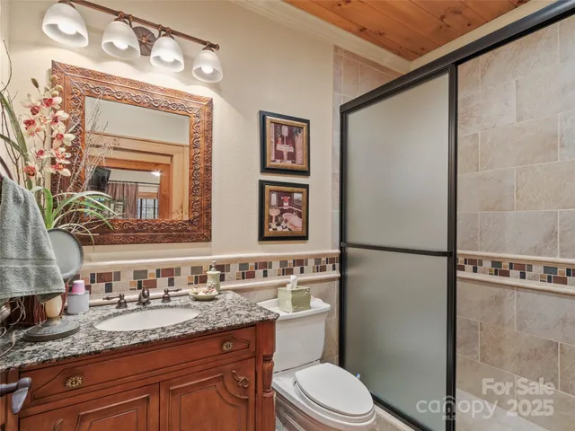 a bathroom with a granite countertop sink mirror vanity and toilet