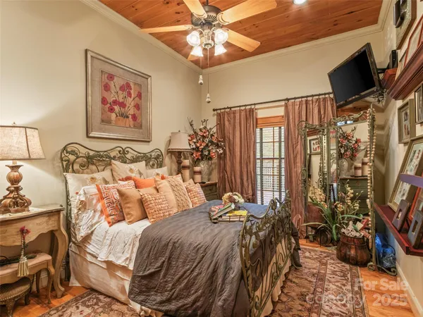 a bedroom with a bed a flat screen tv and a window