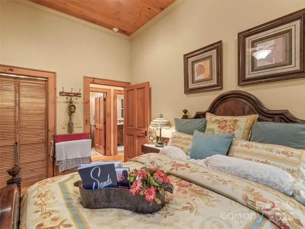 a bedroom with bed and a painting on the wall