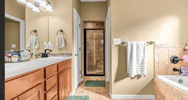 a spacious bathroom with a tub sink and mirror