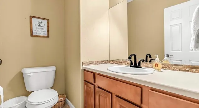 a bathroom with a toilet sink and mirror