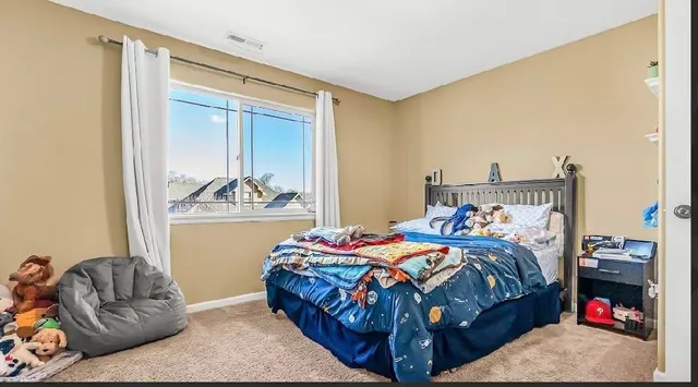 a bedroom with a bed and a couch next to a window